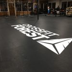 Custom CrossFit Forest logo decal applied on a black gym floor.