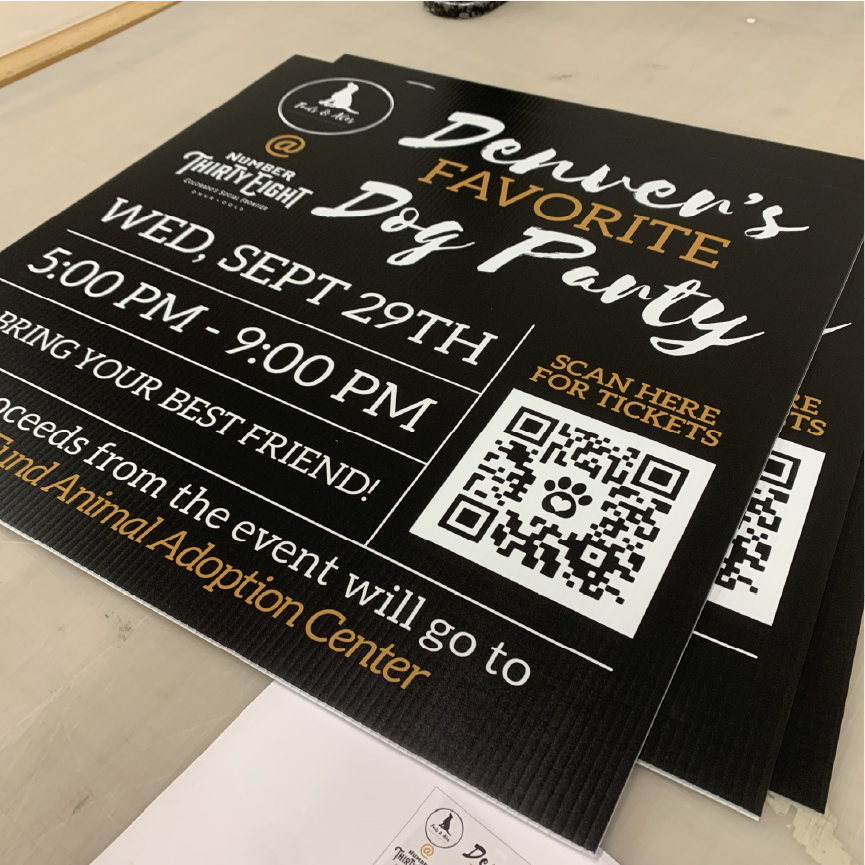 Black coroplast sign promoting a dog adoption fundraiser event