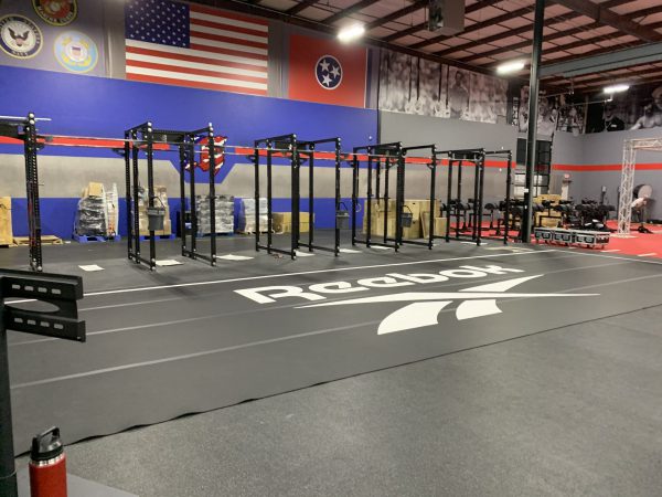 Branded gym floor decal featuring bold CrossFit Forest lettering.