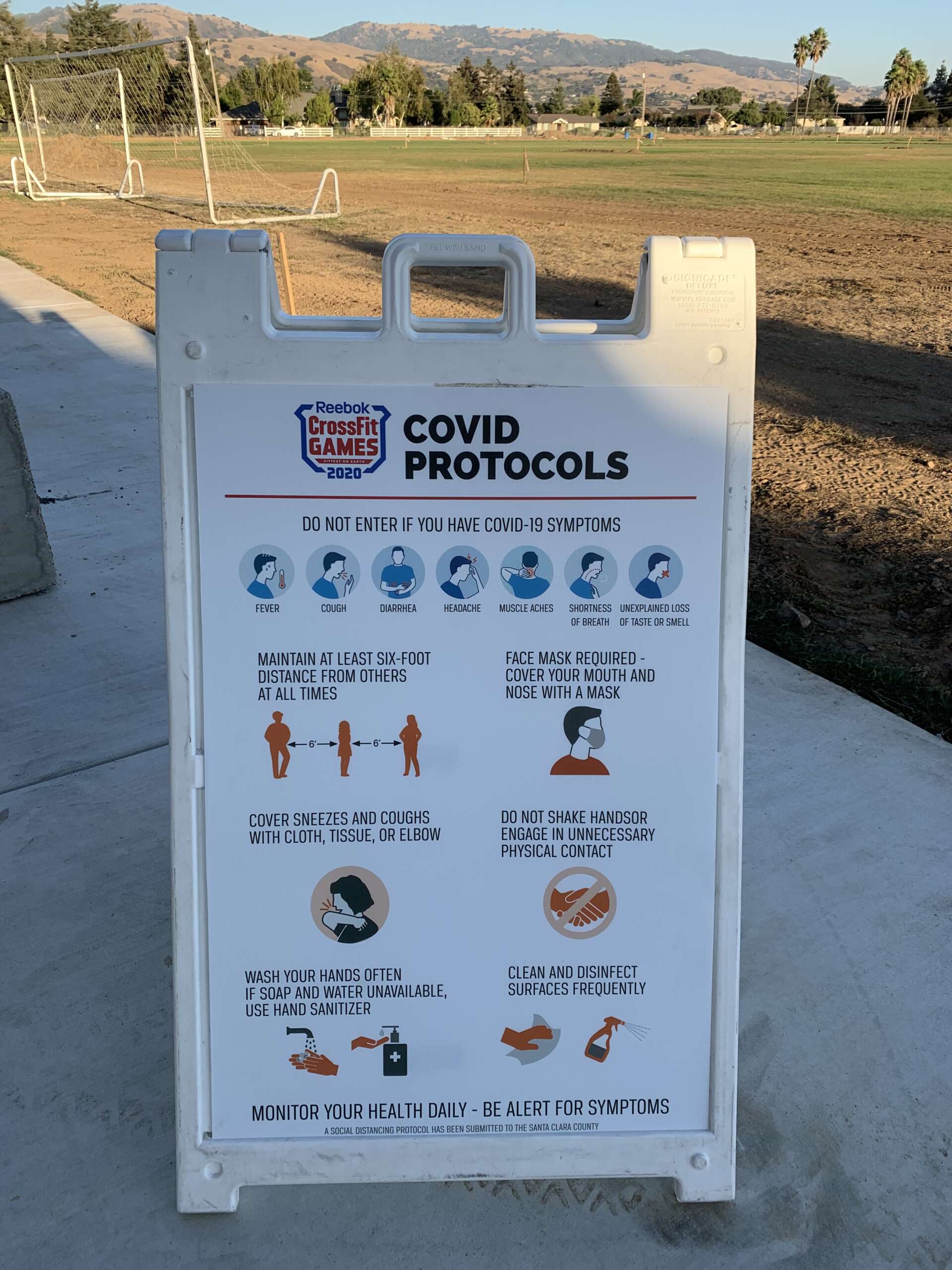 A-frame sign with COVID-19 safety protocols at a CrossFit event