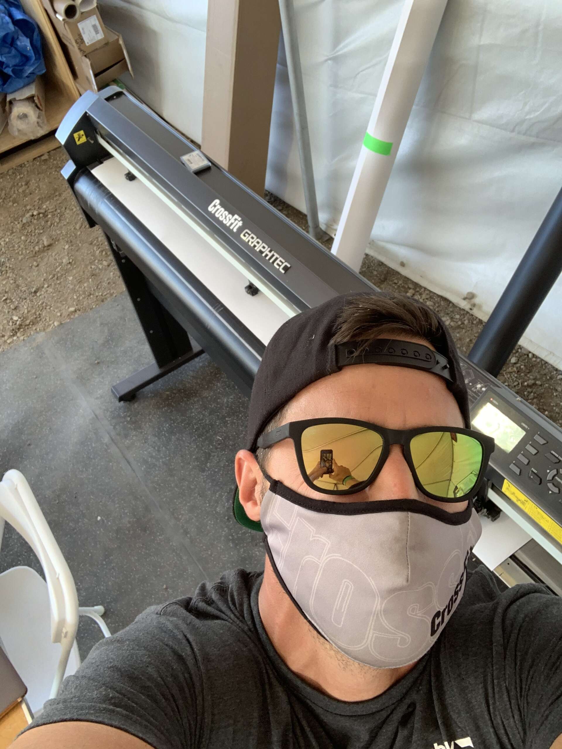 Man in mask taking selfie near CrossFit Graphtec cutter