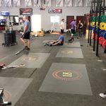 CrossFit gym with numbered floor decals marking individual workout stations.