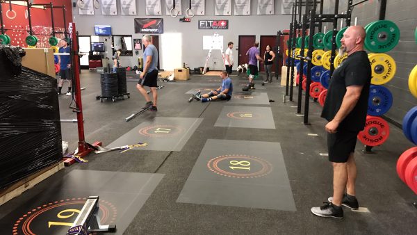 CrossFit gym with numbered floor decals marking individual workout stations.