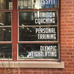 Gym window lettering listing CrossFit, coaching, and personal training
