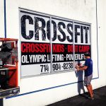 CrossFit window graphic with bold class offerings and contact info.