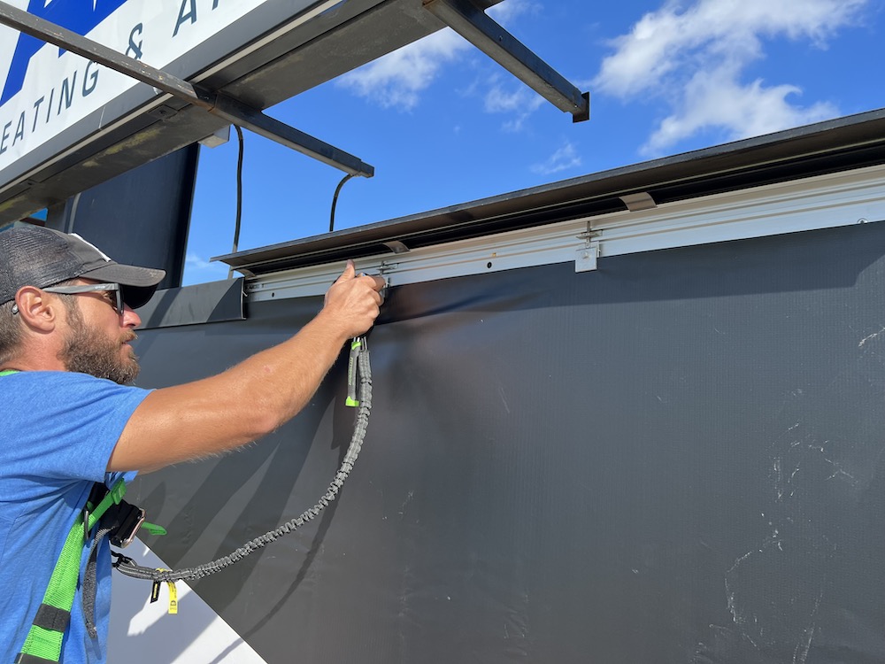 Close-up shot of hands affixing a durable banner