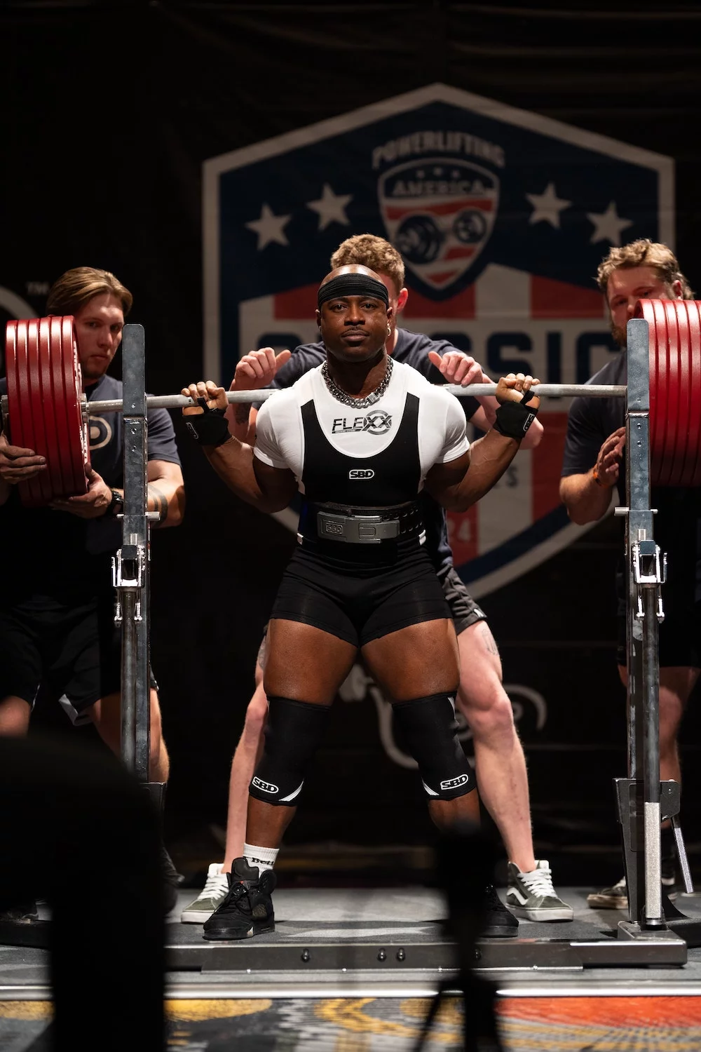 Powerlifter prepares to squat heavy barbell at Powerlifting America event