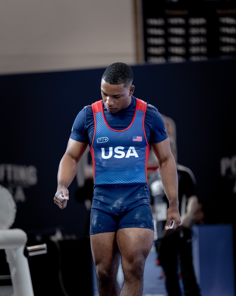 Focused athlete in USA singlet during powerlifting meet